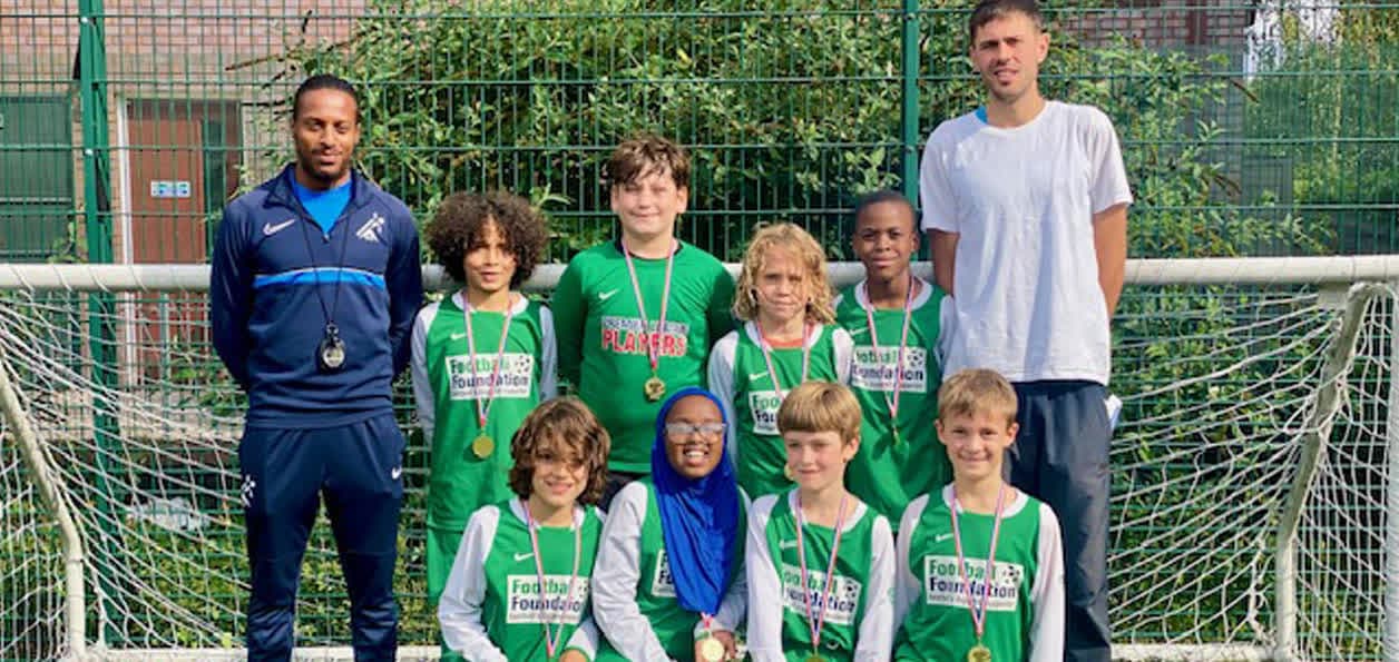 SG Sports Coaching after-school club team with their medals