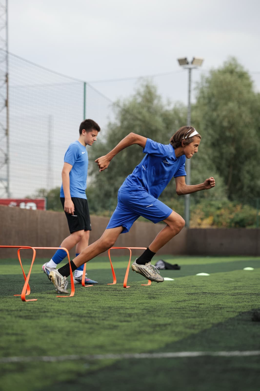 Player sprinting through agility hurdles